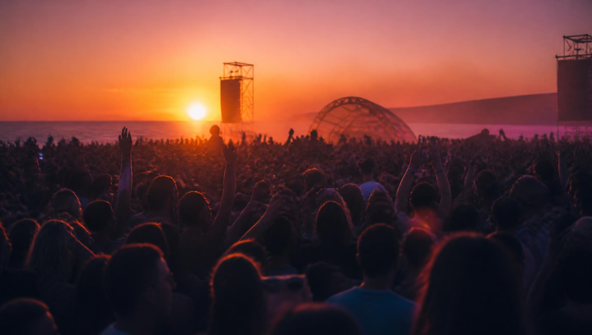 Ausverkauftes Open-Air-Publikum bei Sonnenuntergang am Meer